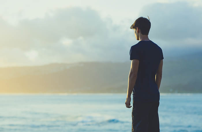 Young man staring out at the ocean